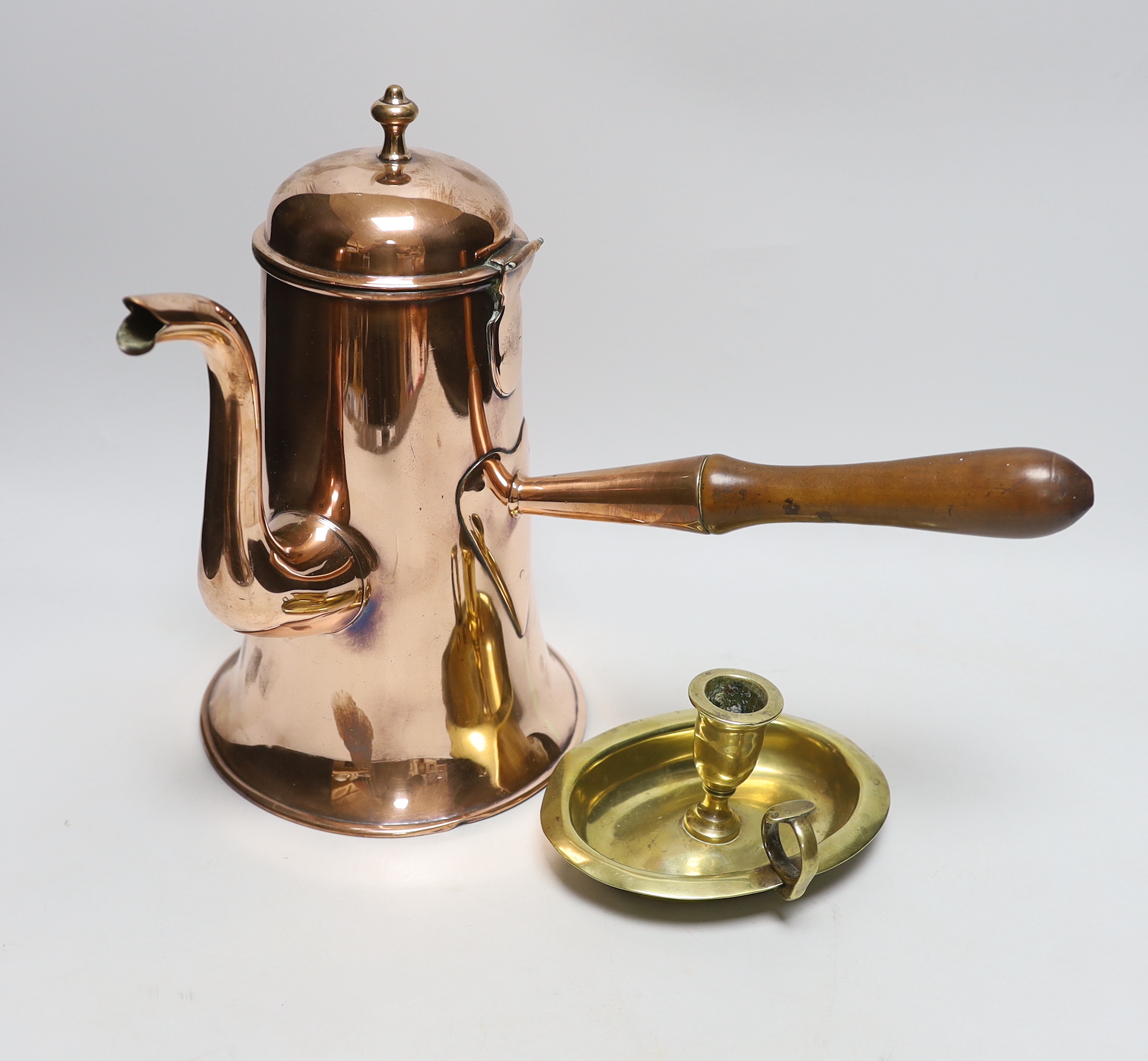 An 18th century copper chocolate pot and a brass chamberstick, tallest 28cm